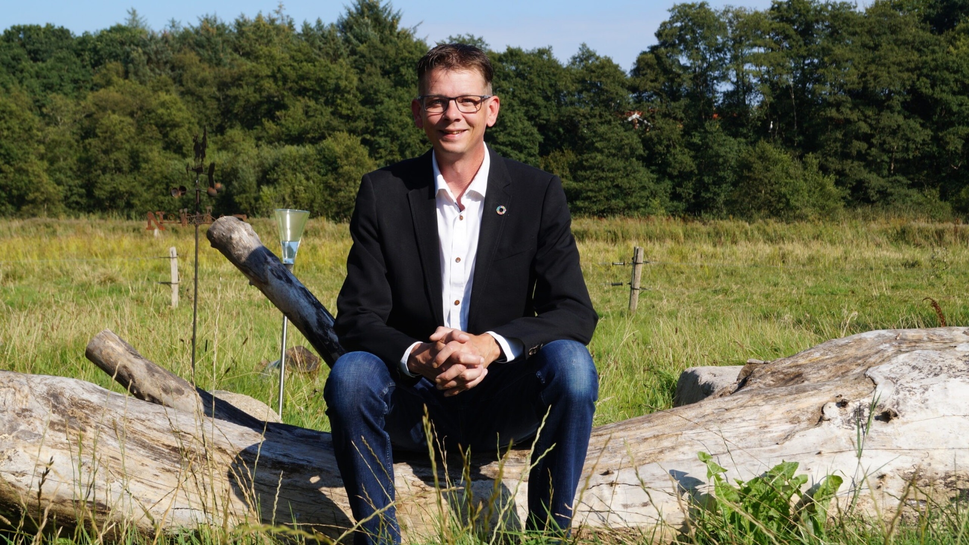Torben Rohde siddende på en træstamme i naturen